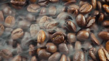 Kavrulmuş kahve çekirdekleri ve tavada duman.