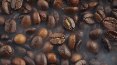 Kavrulmuş kahve çekirdekleri ve tavada duman.