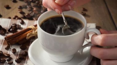 Kahveyi bir kaşıkla karıştırıyorum.