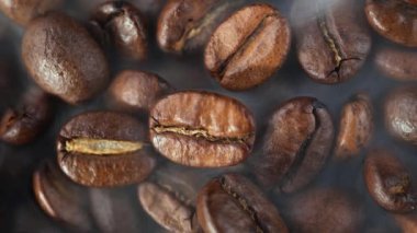 Kavrulmuş kahve çekirdekleri ve tavada duman.