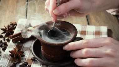 Kahveyi bir kaşıkla karıştırıyorum.