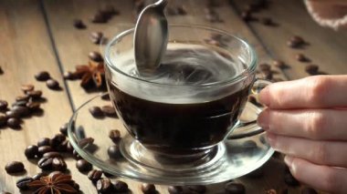 Kahveyi bir kaşıkla karıştırıyorum.