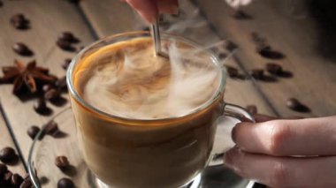 Kahveyi bir kaşıkla karıştırıyorum.