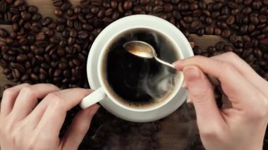 Kahveyi bir kaşıkla karıştırıyorum.