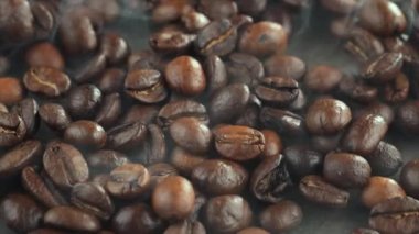 Kavrulmuş kahve çekirdekleri ve tavada duman.