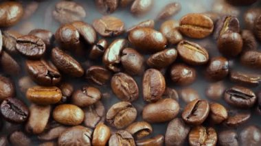 Kavrulmuş kahve çekirdekleri ve tavada duman.