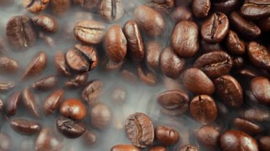 Kavrulmuş kahve çekirdekleri ve tavada duman.