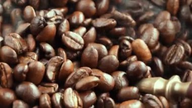 Kavrulmuş kahve çekirdekleri ve tavada duman.