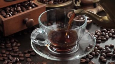 Kahve fincanından kahve fincanına buharlı kahve döküldü.