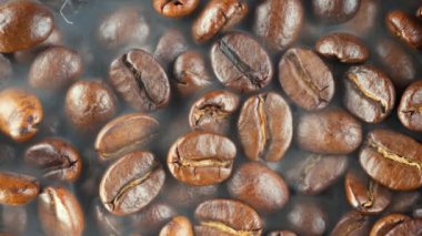 Kavrulmuş kahve çekirdekleri ve tavada duman.