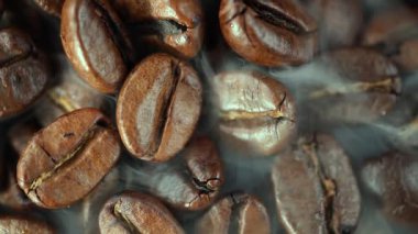 Kavrulmuş kahve çekirdekleri ve tavada duman.