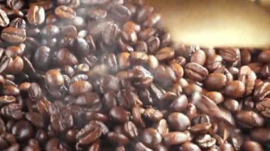 Kavrulmuş kahve çekirdekleri, tavada dumanla karıştırılır..