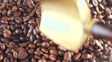 Kavrulmuş kahve çekirdekleri, tavada dumanla karıştırılır..