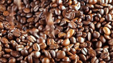 Kavrulmuş kahve çekirdekleri ve tavada duman.