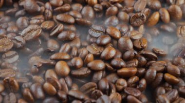 Kavrulmuş kahve çekirdekleri ve tavada duman.