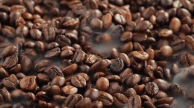 Kavrulmuş kahve çekirdekleri ve tavada duman.