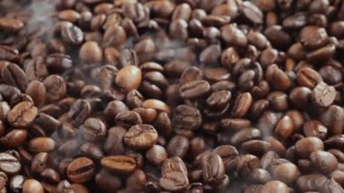 Kavrulmuş kahve çekirdekleri ve tavada duman.