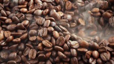 Kavrulmuş kahve çekirdekleri ve tavada duman.