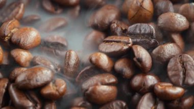 Kavrulmuş kahve çekirdekleri ve tavada duman.