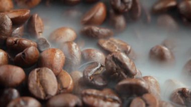 Kavrulmuş kahve çekirdekleri ve tavada duman.