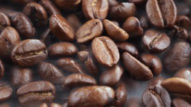 Kavrulmuş kahve çekirdekleri ve tavada duman.