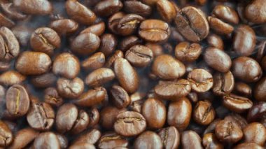 Kavrulmuş kahve çekirdekleri ve tavada duman.