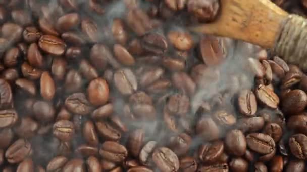 焙煎したコーヒー豆をスプーンでパンの煙と混ぜ合わせます — ストック動画