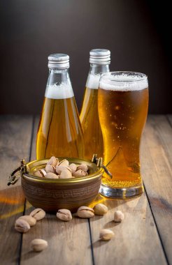 Masadaki bardakta hafif bira kompozisyonu ve eski bir arka planda aksesuar.