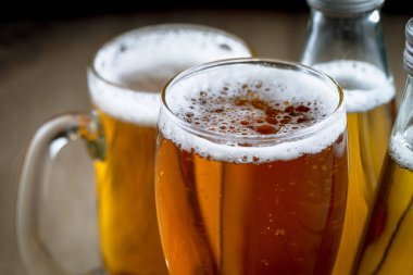 Masadaki bardakta hafif bira kompozisyonu ve eski bir arka planda aksesuar.