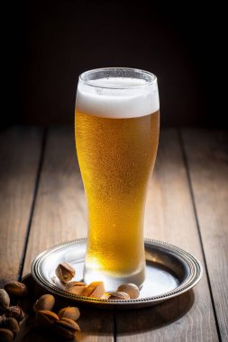 Masadaki bardakta hafif bira kompozisyonu ve eski bir arka planda aksesuar.