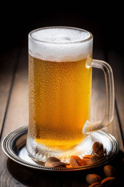 Masadaki bardakta hafif bira kompozisyonu ve eski bir arka planda aksesuar.