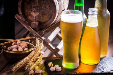 Masadaki bardakta hafif bira kompozisyonu ve eski bir arka planda aksesuar.