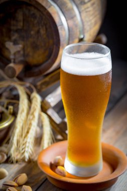 Masadaki bardakta hafif bira kompozisyonu ve eski bir arka planda aksesuar.