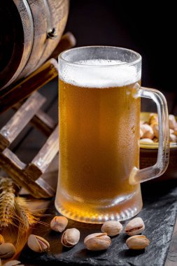 Masadaki bardakta hafif bira kompozisyonu ve eski bir arka planda aksesuar.