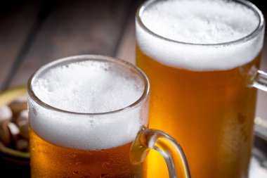 Masadaki bardakta hafif bira kompozisyonu ve eski bir arka planda aksesuar.