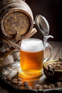 Masadaki bardakta hafif bira kompozisyonu ve eski bir arka planda aksesuar.