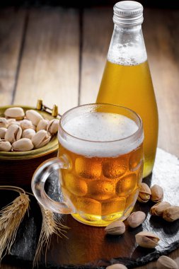 Masadaki bardakta hafif bira kompozisyonu ve eski bir arka planda aksesuar.