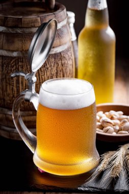 Masadaki bardakta hafif bira kompozisyonu ve eski bir arka planda aksesuar.