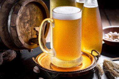 Masadaki bardakta hafif bira kompozisyonu ve eski bir arka planda aksesuar.