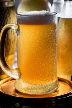 Masadaki bardakta hafif bira kompozisyonu ve eski bir arka planda aksesuar.