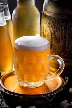 Masadaki bardakta hafif bira kompozisyonu ve eski bir arka planda aksesuar.