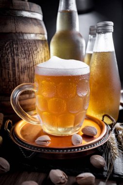 Masadaki bardakta hafif bira kompozisyonu ve eski bir arka planda aksesuar.
