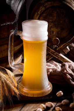 Masadaki bardakta hafif bira kompozisyonu ve eski bir arka planda aksesuar.