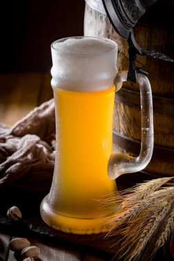 Masadaki bardakta hafif bira kompozisyonu ve eski bir arka planda aksesuar.