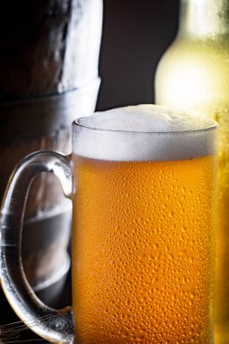 Masadaki bardakta hafif bira kompozisyonu ve eski bir arka planda aksesuar.
