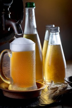 Masadaki bardakta hafif bira kompozisyonu ve eski bir arka planda aksesuar.