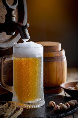 Masadaki bardakta hafif bira kompozisyonu ve eski bir arka planda aksesuar.