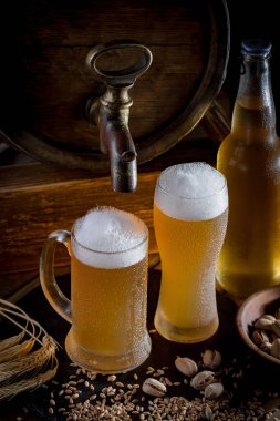 Masadaki bardakta hafif bira kompozisyonu ve eski bir arka planda aksesuar.