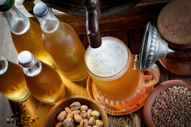 Masadaki bardakta hafif bira kompozisyonu ve eski bir arka planda aksesuar.