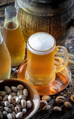 Masadaki bardakta hafif bira kompozisyonu ve eski bir arka planda aksesuar.